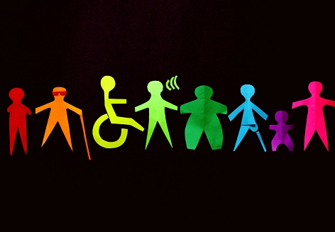 Kleine ausgeschnittene Figuren in Regenbogenfarben, die verschiedene Behinderungen darstellen.